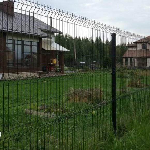 Забор из сварной 3D сетки перед домом с зелёным газоном